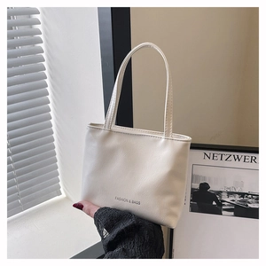 Détail du sac à main en cuir PU crème avec l'inscription Fashion & Bags imprimée