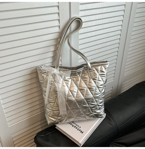 Détail du sac cabas matelassé argenté avec nœud en dentelle blanche et boucle dorée