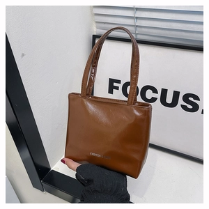 Détail du sac cabas marron brillant avec l'inscription blanche FASHION & BAGS