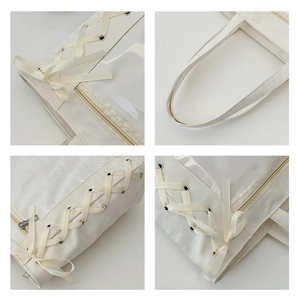 Detail view of large tote bag showing ribbon lace-up, bow design, and clear PVC panel