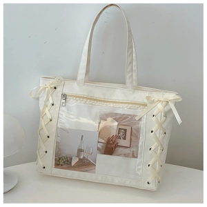 Detail of canvas tote bag with transparent PVC window and elegant ribbon side lacing