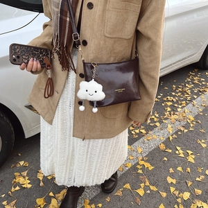 Fashionable dark brown leather bucket bag with cute white plush charm for autumn