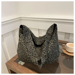 Detail shot of large leopard print canvas tote bag on a modern glass coffee table