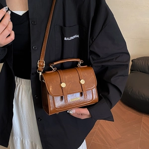 Vintage brown leather crossbody handbag with gold hardware and fashion lettering design