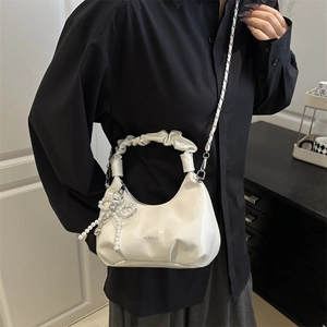 Chic milk white dumpling bag with soft pleats, metal chain, and pearl bow detail