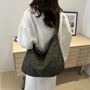 Stylish large leopard print canvas tote bag with wide strap worn by model in room