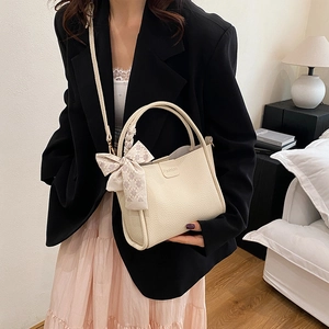 Chic beige lychee leather tote bag with woven handles and silk scarf on a model