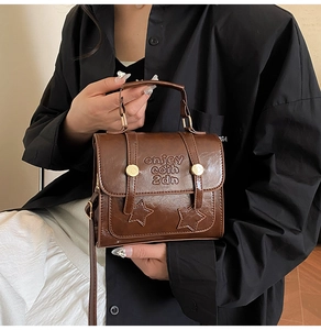 Détail d'un sac bandoulière vintage caramel avec gaufrage d'étoiles et rivets dorés