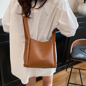 Brown litchi grain leather bucket bag with Fashion embossing shown on model back