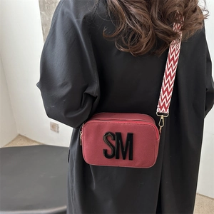 Dark red rectangular camera bag with SM letter and wavy wide shoulder strap
