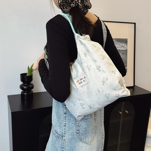 Floral canvas tote bag with bunny pattern and drawstring closure shown in lifestyle setting