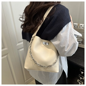 Détail du sac cabas en cuir beige avec chaîne argentée et fermoir pivotant élégant
