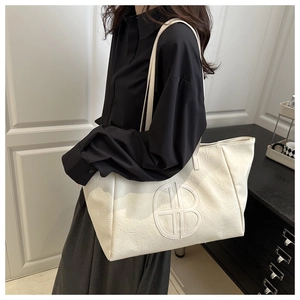 Detailed view of cream white tote bag with circular B stitching on shoulder