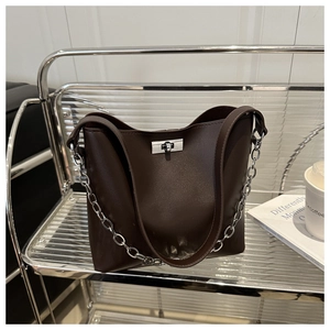 Détail du sac seau marron foncé avec fermoir pivotant argenté et bandoulière chaîne