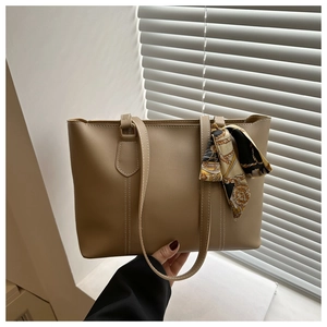 Detail of minimalist tote bag with contrast stitching and floral silk scarf accessory