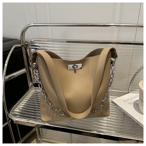 Détail du sac seau beige avec fermoir rotatif argenté et bandoulière chaîne