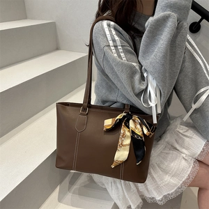 Minimalist brown faux leather tote bag with white stitching and printed silk scarf detail
