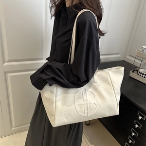 Minimalist large capacity tote bag in cream white faux leather with embossed logo design