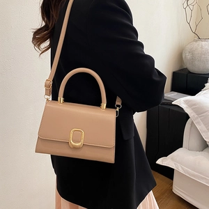 Elegant beige crossbody handbag with golden metal buckle and adjustable shoulder strap