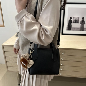 Classic black litchi pattern bucket tote bag with leather straps and plush charm