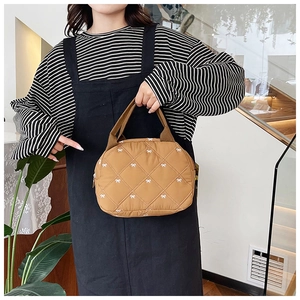 Trousse de maquillage matelassée marron avec motifs de nœuds blancs et poignée en toile