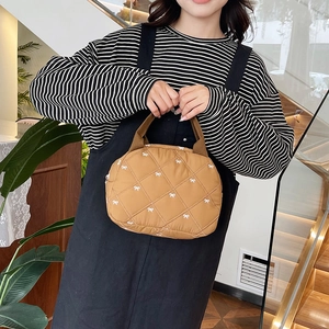 Sac à main matelassé marron avec broderie de nœuds blancs et poignées robustes