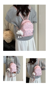 Detailed view of pink floral backpack featuring a cute white cloud plush pendant charm