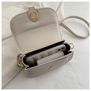 Detailed interior view of a cream faux leather saddle bag showing mobile phone storage