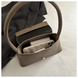 Détail de l'intérieur du sac beige en demi-lune montrant l'espace pour téléphone et portefeuille
