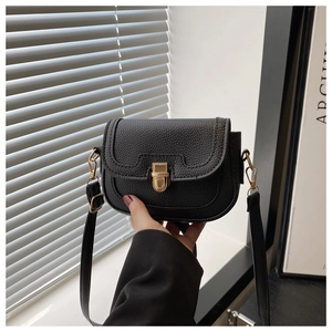 Close-up of black litchi pattern leather crossbody bag with golden metal lock buckle