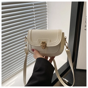 Close-up of white crossbody bag with premium lychee texture and golden twist lock
