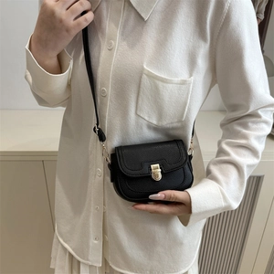 Minimalist black lychee leather crossbody bag with wave flap and gold latch closure