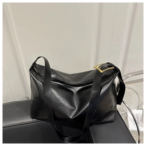 Close-up of black PU leather tote bag showing golden buckle and smooth matte texture