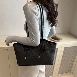 Chic black tote bag with diagonal texture and gold metal accents for casual daily wear
