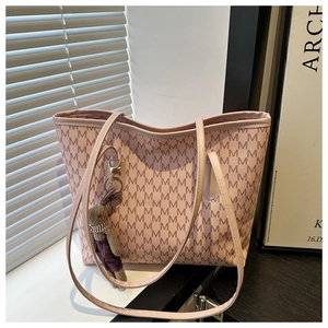 Detailed view of pink monogram tote bag with a cute plush rabbit accessory charm