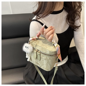 Detail of mint green marble crossbody bag with silk scarf handle and plush monster charm