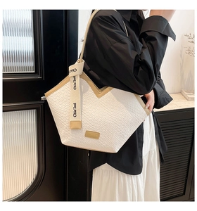 Détail de la texture tissée blanche et de la bordure en cuir en V du sac cabas fourre-tout