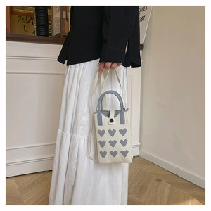 Vue détaillée du mini sac en tricot avec motif de cœur gris et poignée ronde