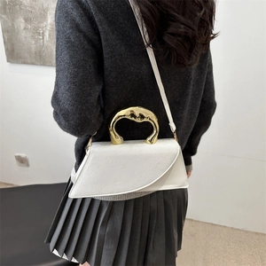 White leather handbag with unique gold metal handle worn by model for casual chic style