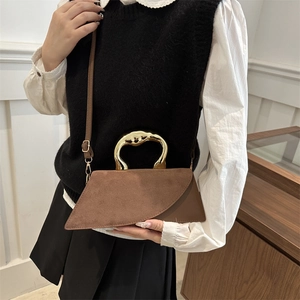 Brown suede geometric tote bag with wavy gold metal handle and crossbody strap