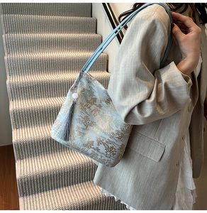Detail of blue satin tote with gold landscape embroidery and long tassel charm