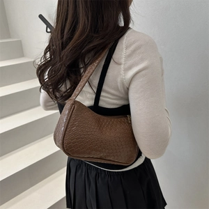 Woven leather shoulder bag for women, chic brown underarm purse with stylish woven texture.