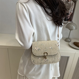 Straw saddle crossbody bag with floral embroidery and golden horseshoe buckle