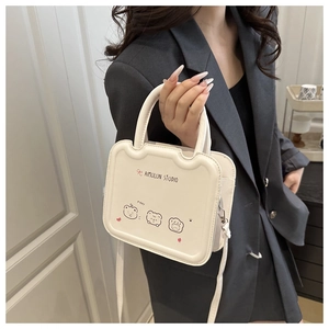 Detail of creamy white crossbody bag with wave edges and cartoon bear illustrations
