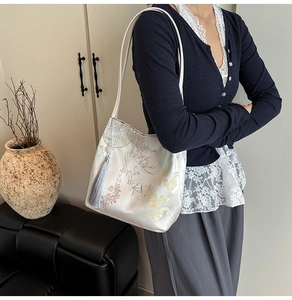 Detail of elegant Chinese style tote bag with silk embroidery and decorative tassels