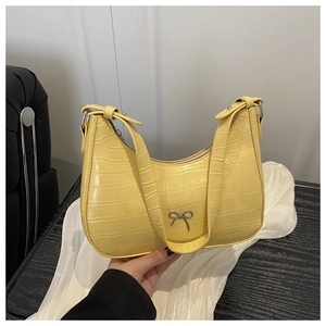 Detailaufnahme der gelben Krokodilstruktur-Schultertasche mit silberner Metallschleife