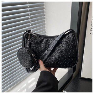 Detail of black woven shoulder bag with a small round pouch and silver hardware