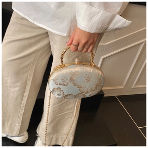 Detail of light blue evening bag with gold peony embroidery and crystal ball clasp