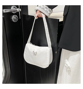 Detail of white nylon underarm bag with silver butterfly buckle on a black suit outfit