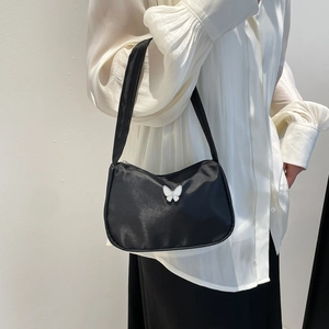 Chic black underarm bag with white butterfly buckle and glossy finish for women